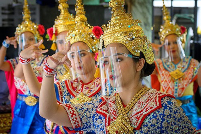 Các vũ công Thái Lan đeo mặt nạ bảo hộ trình diễn tại đền Erawan nổi tiếng linh thiêng ở Bangkok hôm 4/5. Đền vừa mở cửa trở lại sau khi Chính phủ Thái Lan nới lỏng các biện pháp phòng chống Covid-19. (Ảnh: AFP) 